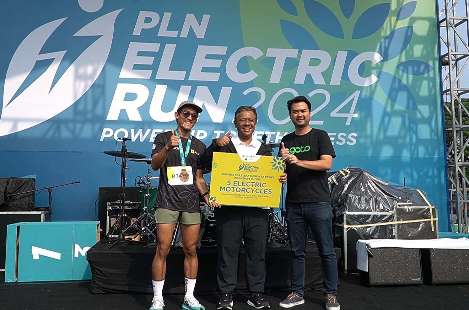 Direktur Legal & Manajemen Human Capital PLN Yusuf Didi Setiarto (tengah) menjelaskan, lima unit motor listrik yang disalurkan pada pengemudi ojol prasejahtera merupakan hasil konversi 14.363 kg emisi karbon yang sukses dihindari oleh 6.470 peserta saat berpartisipasi pada ajang PLN Electric Run 2024. Dok PLN