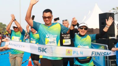 Direktur Utama PLN, Darmawan Prasodjo (kiri) bersama istri, Diny Darmawan Prasodjo (kanan) saat melintasi garis finish dan menyelesaikan PLN Electric Run 2024 kategori 5K. Dok PLN